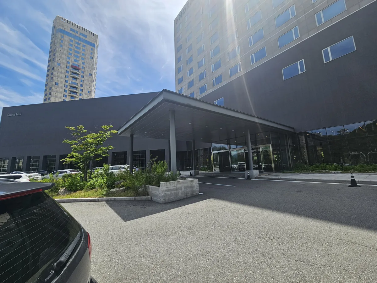 The Phoenix Hotel entrance at Forest Hall, with the condo tower rising behind